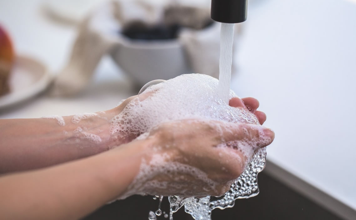 Image of person washing hands with soap and water